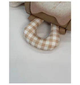 Close-up of thickened plush handle with beige checkerboard pattern on casual backpack