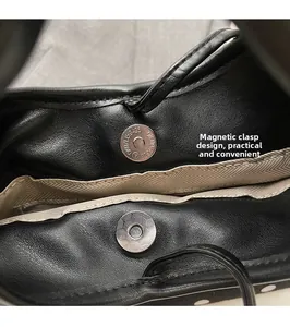Détail du fermoir magnétique sur sac en cuir noir avec doublure résistante à chevrons