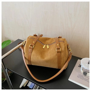 Détail du sac Boston vintage en faux daim marron avec garniture en cuir et zips dorés