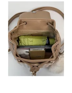 Interior view of beige leather backpack showing capacity for umbrella and phone