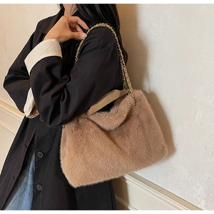 Gros plan d'un sac à main beige en fausse fourrure avec chaîne dorée et anse en cuir