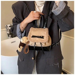 Detail of khaki and black bucket backpack with faux fur flap and cute bear pendant