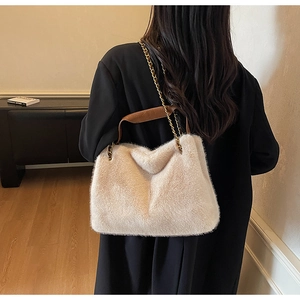 Détail du sac fourre-tout en fausse fourrure beige avec chaîne dorée et anses en cuir