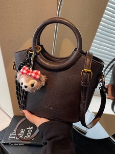 Sac seau en simili cuir marron foncé avec deux poignées et un charme en peluche