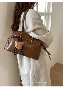 Sac fourre-tout rétro en cuir ciré marron porté épaule avec pendentif d'ours