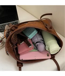 Top view of large brown suede tote bag showing spacious interior with tablet and umbrella