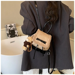 Detail of plush bucket backpack with glossy bow and cute brown bear charm accessory