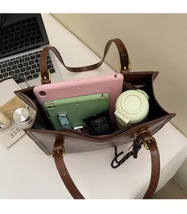 Top view of large brown leather tote bag showing spacious interior with tablet and bottle