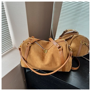 Détails du sac Boston en daim caramel avec quincaillerie dorée et bandoulières