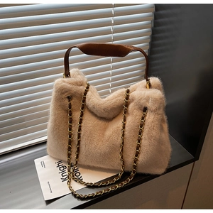 Détail du sac cabas beige en fausse fourrure avec chaîne en métal et poignée en cuir