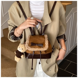 Detail of mini backpack with brown faux fur trim and cute bear keychain accessory