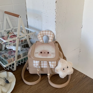 Detailed shot of beige mini backpack with cat embroidery and star plush pendant