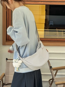 Borsa a tracolla a mezzaluna in nylon grigio chiaro con ciondolo a forma di orso