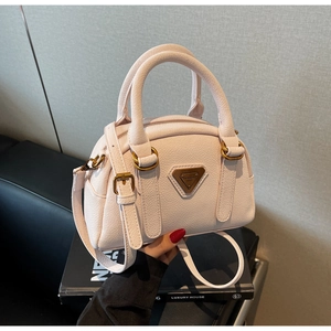 Close-up of pink Boston bag showing lychee leather texture and metal logo detail