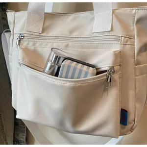 Vue détaillée du sac cabas en toile avec poches multiples montrant la capacité
