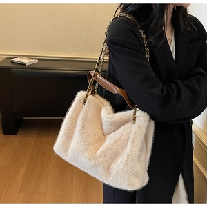 Détail du sac fourre-tout en fausse fourrure beige avec anse en cuir et bandoulière dorée