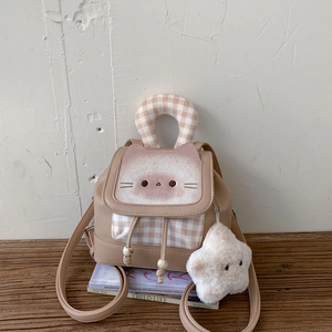 Detail of a beige cat-themed mini backpack with plush embroidery and plaid accents