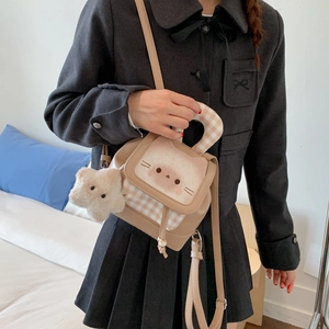 Close-up of cat-patterned mini backpack with plaid details and star plush charm