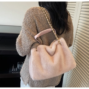 Détail latéral d'un cabas en fausse fourrure rose avec chaîne en métal et texture douce