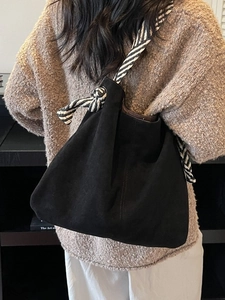 Vintage black tote bag with striped silk scarf handle on model in autumn setting