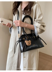 Détail du sac cabas vintage en cuir ciré noir avec breloque ours et boucle dorée