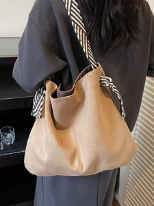 Khaki suede tote bag with geometric woven strap for women in a cozy home setting
