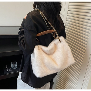 Gros plan du sac à bandoulière en peluche blanche avec chaîne dorée et poignée en cuir