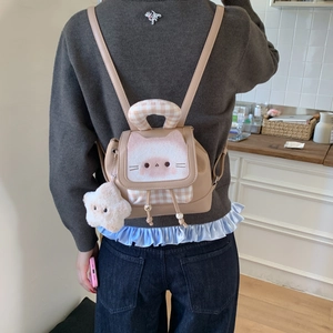 Detail of cute cat-themed mini backpack with plush lid and star charm shown on model
