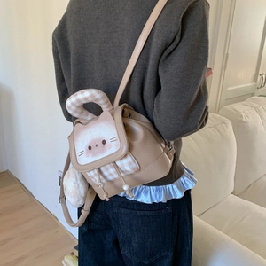 Close-up of khaki mini backpack with cute cat face design and bunny ear details