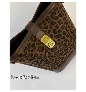 Gros plan du sac seau léopard avec fermoir pivotant doré et bordures en cuir