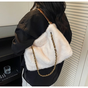Détail du sac en fausse fourrure blanche avec chaîne dorée et bandoulière en cuir marron