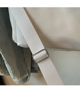 Détail de la bandoulière blanche ajustable avec boucle en métal argenté du sac