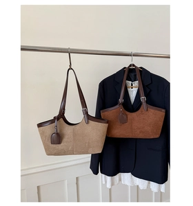 Detail of vintage suede tote bags in khaki and coffee brown hanging with office attire