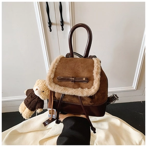 Detail view of mini brown faux suede backpack with plush trim and teddy bear charm