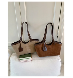Minimalist faux suede tote bags in beige and brown shown on a sofa in a modern room