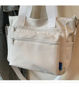 Détail du grand sac cabas en nylon avec poches zippées et poignées en toile tissée