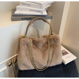 Détail d'un sac à main en fausse fourrure camel avec poignée cuir et chaîne dorée