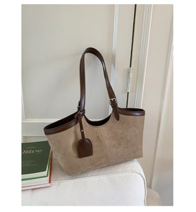 Detailed view of retro patchwork tote bag with suede texture and brown leather trim