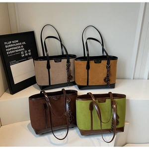 Detailed row of tote bags in gray, khaki, brown, and green with tassel charms
