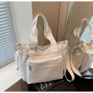 Détail du sac cabas en nylon blanc crème avec poches pratiques et larges poignées tissées