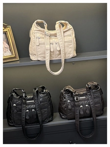Close-up of multi-pocket faux leather shoulder bags in white, black, and dark brown colors