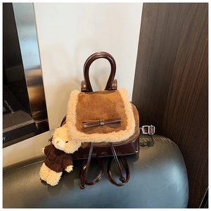 Detail of mini plush backpack with fur trim, leather bow and bear charm