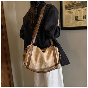 Detail of vintage canvas boston bag with leather straps worn by model in casual style