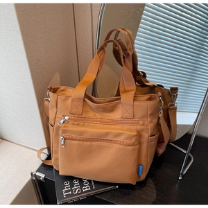Vue détaillée du cabas en nylon caramel avec poches multiples et bandoulière réglable