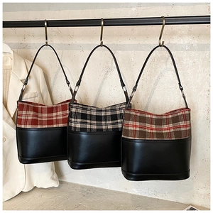 Detailed view of plaid and leather bucket bags hanging in classic vintage color options