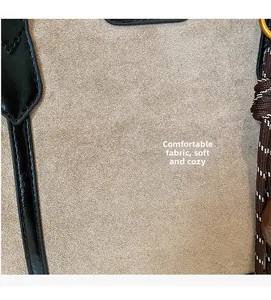 Detailed macro view of beige suede fabric and black leather trim with neat stitching