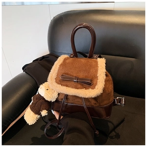 Detail of vintage brown suede backpack with faux fur trim and cute bear charm