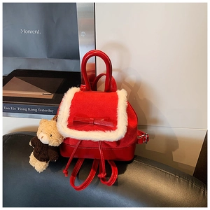 Detail of red bucket backpack with plush fur trim and cute bear keychain accessory