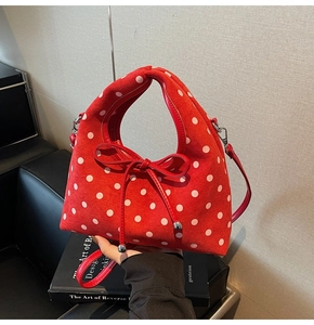 Détail du sac à main en daim rouge à pois blancs avec nœud décoratif élégant