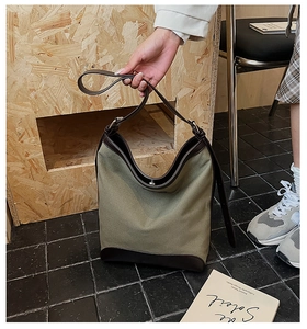 Detailed view of olive green canvas hobo bag with brown leather base and handle